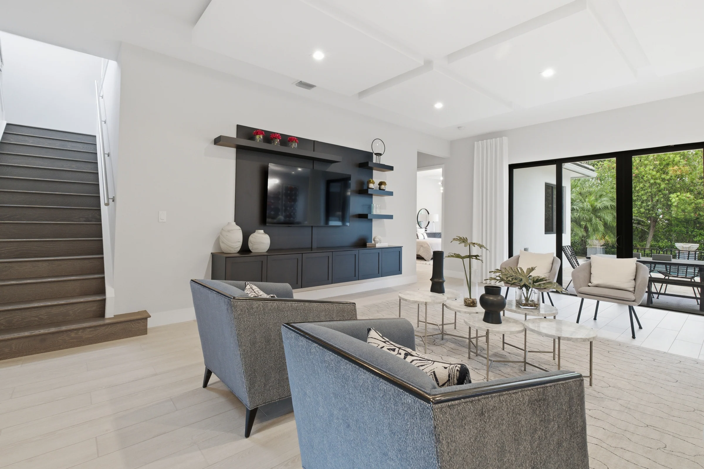 Living room with a media wall beside the staircase