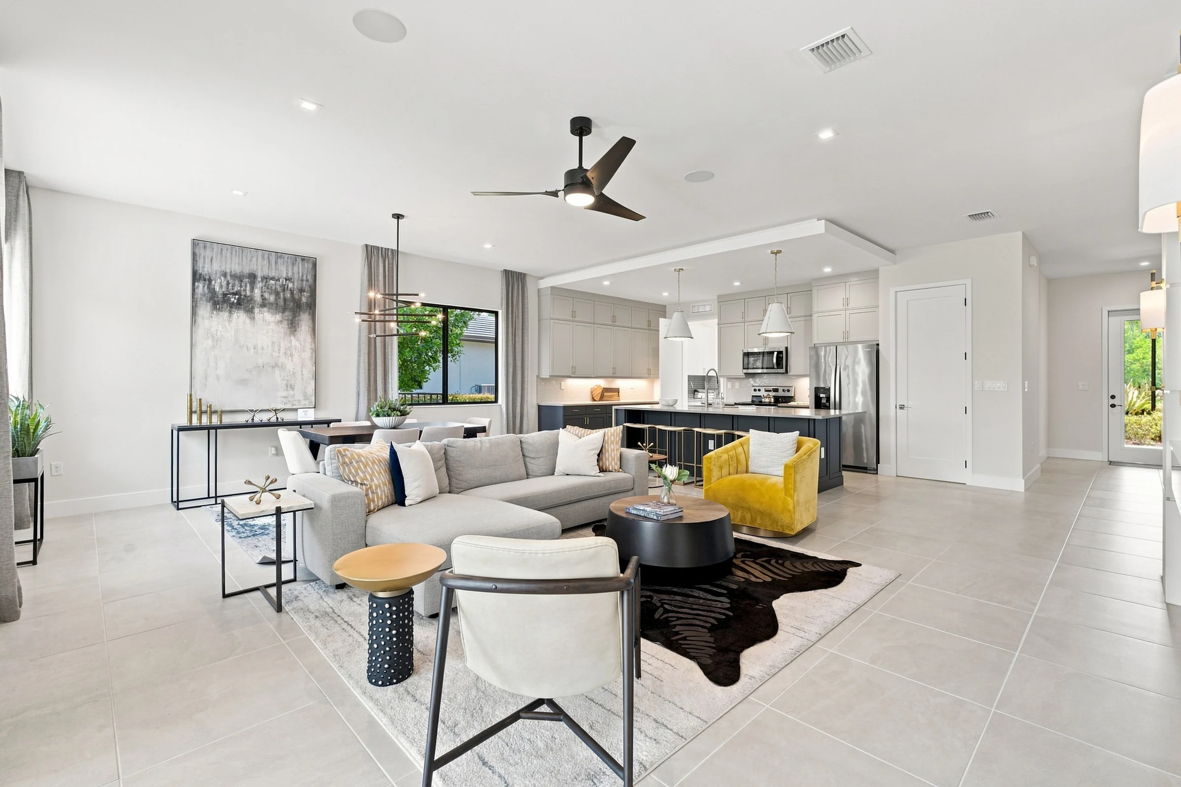 Living room with a sectional sofa, yellow accent chair and ceiling fan