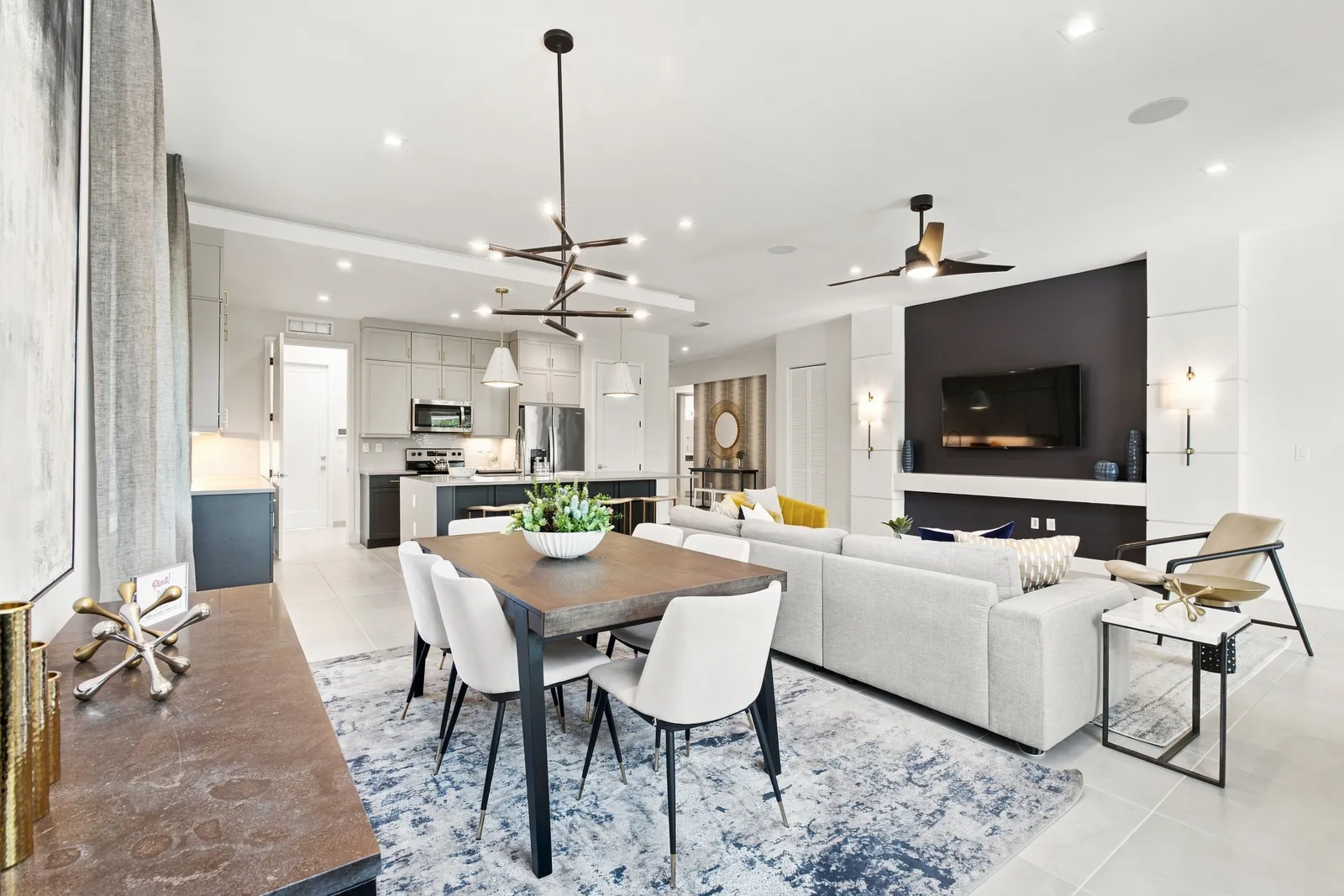 Open-plan dining area flowing into a living room with a fireplace wall