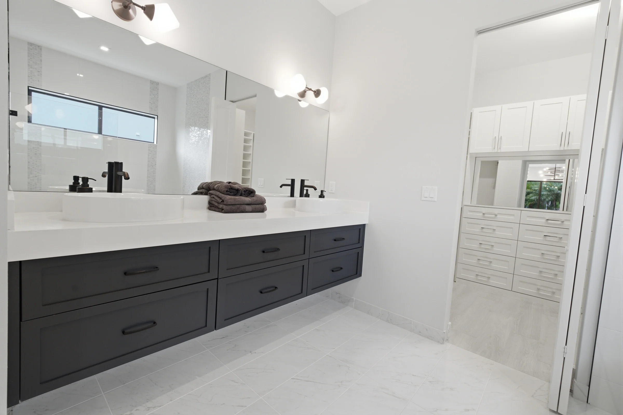 Primary bath with a long dark double vanity