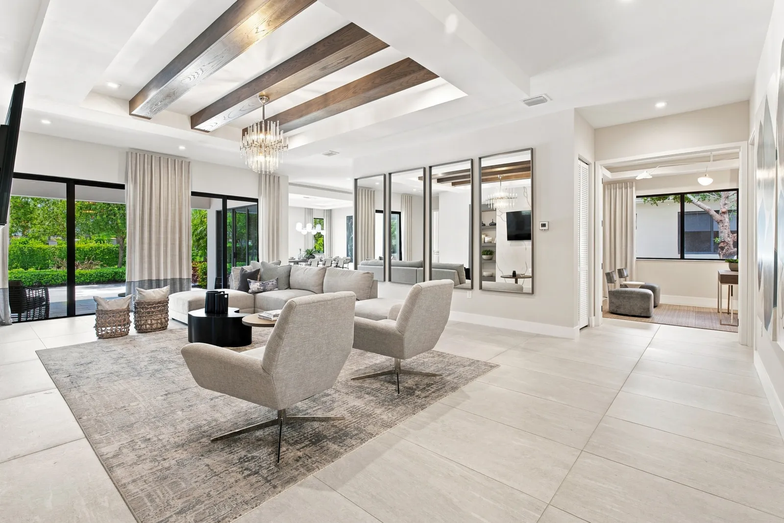 Living room with beamed ceiling, swivel chairs and floor-to-ceiling windows