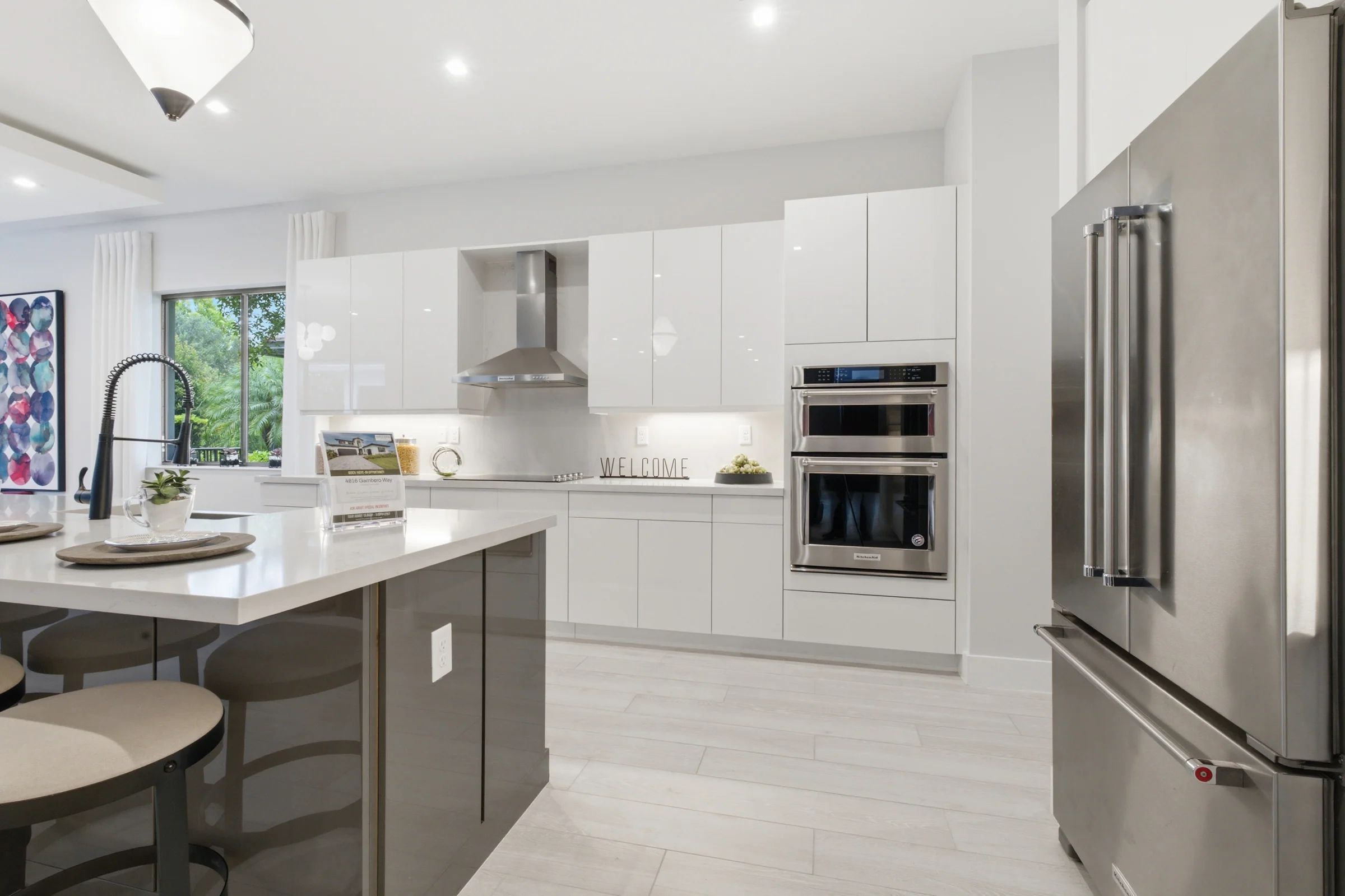 White kitchen with an island and stainless appliances