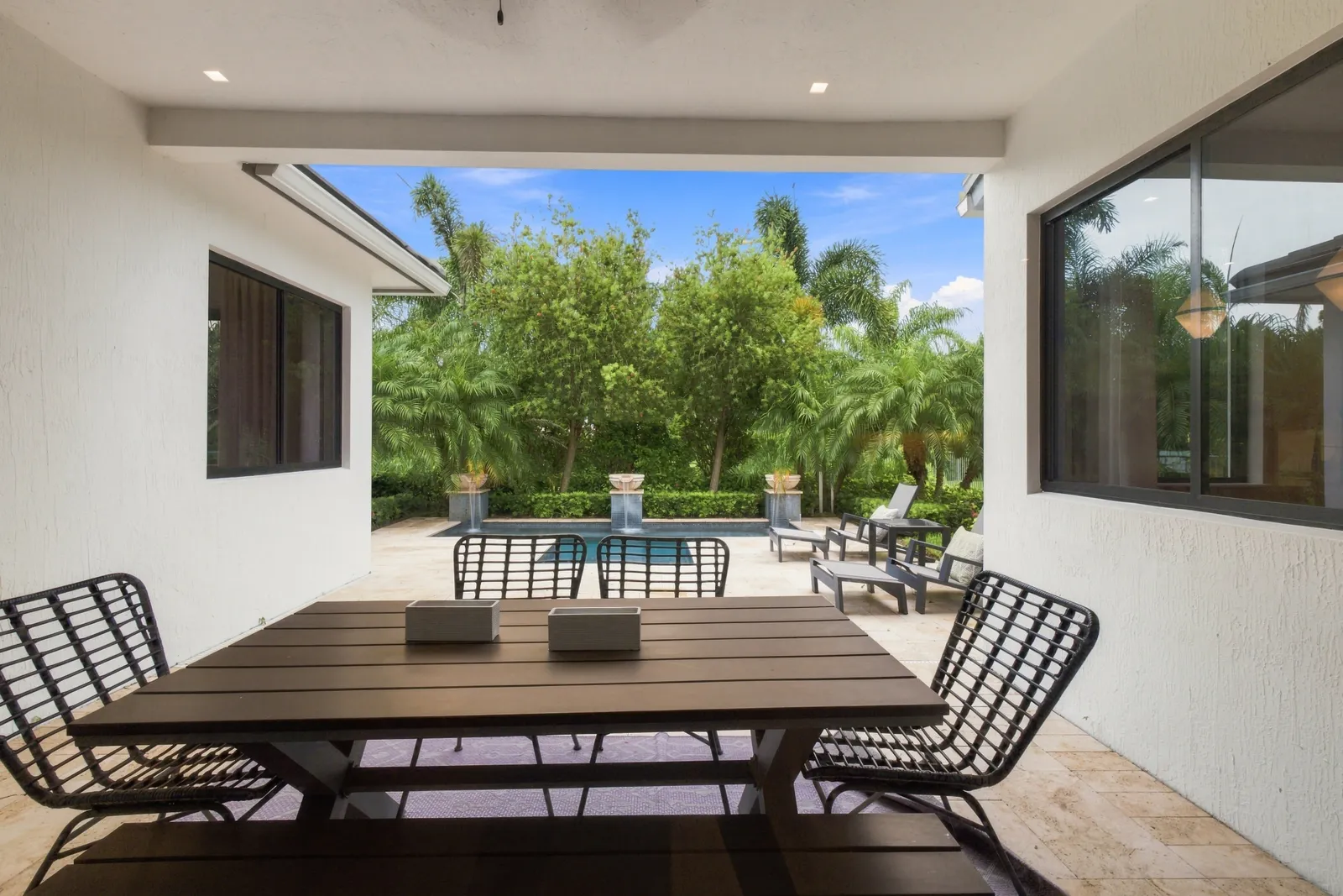 Covered outdoor dining table overlooking the pool and garden