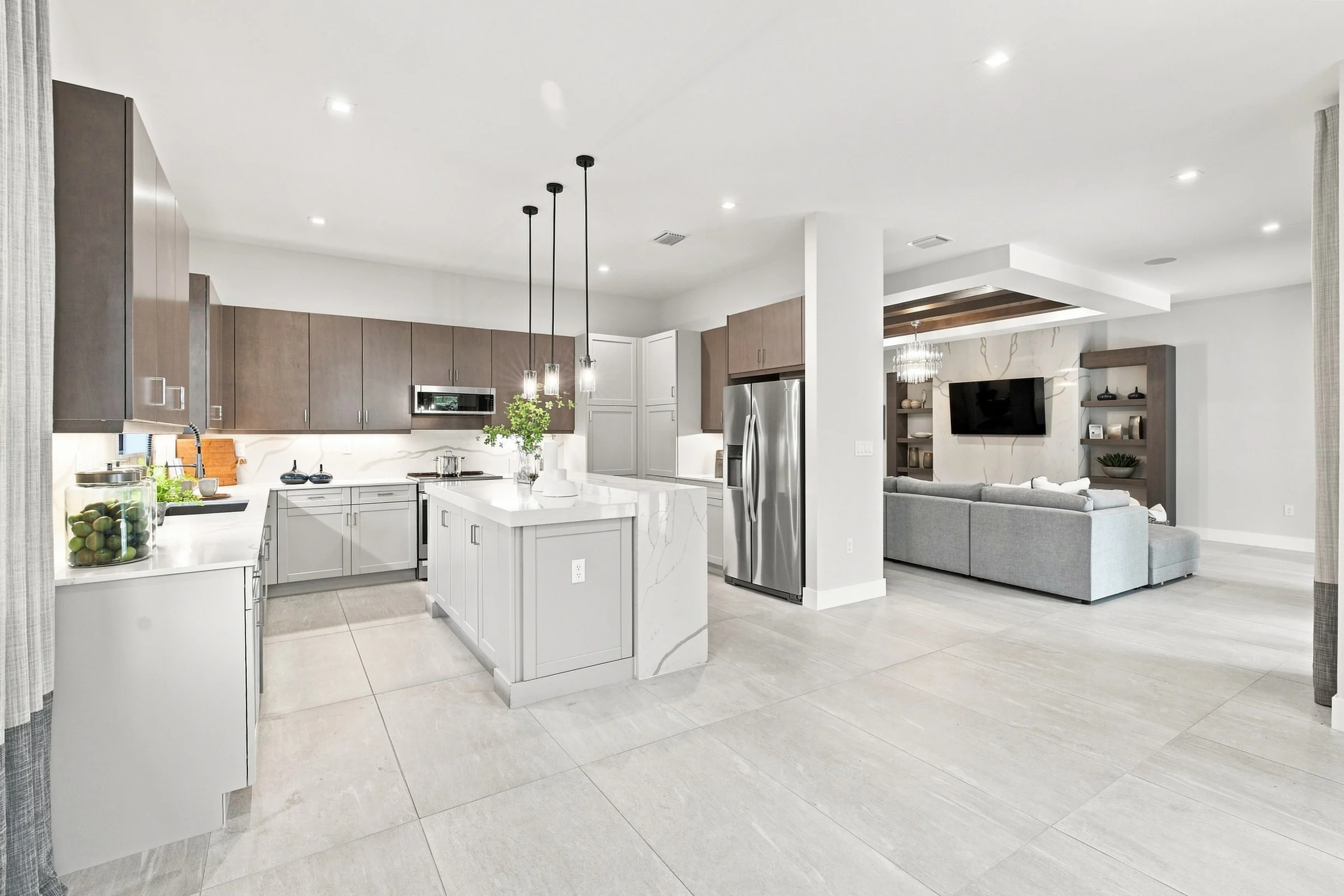 Kitchen with wood upper cabinets, an island and pendant lights