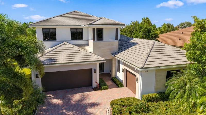 Elevated drone view of the two-story Harbour model home and its paver driveway