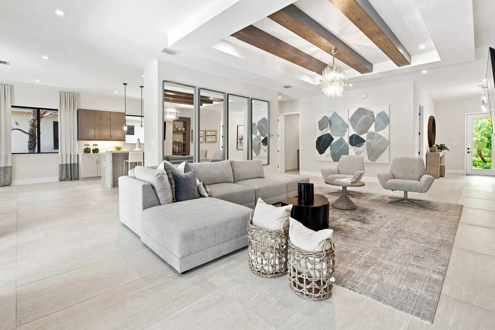 Family room with a sectional sofa and wood ceiling beams opening to the kitchen