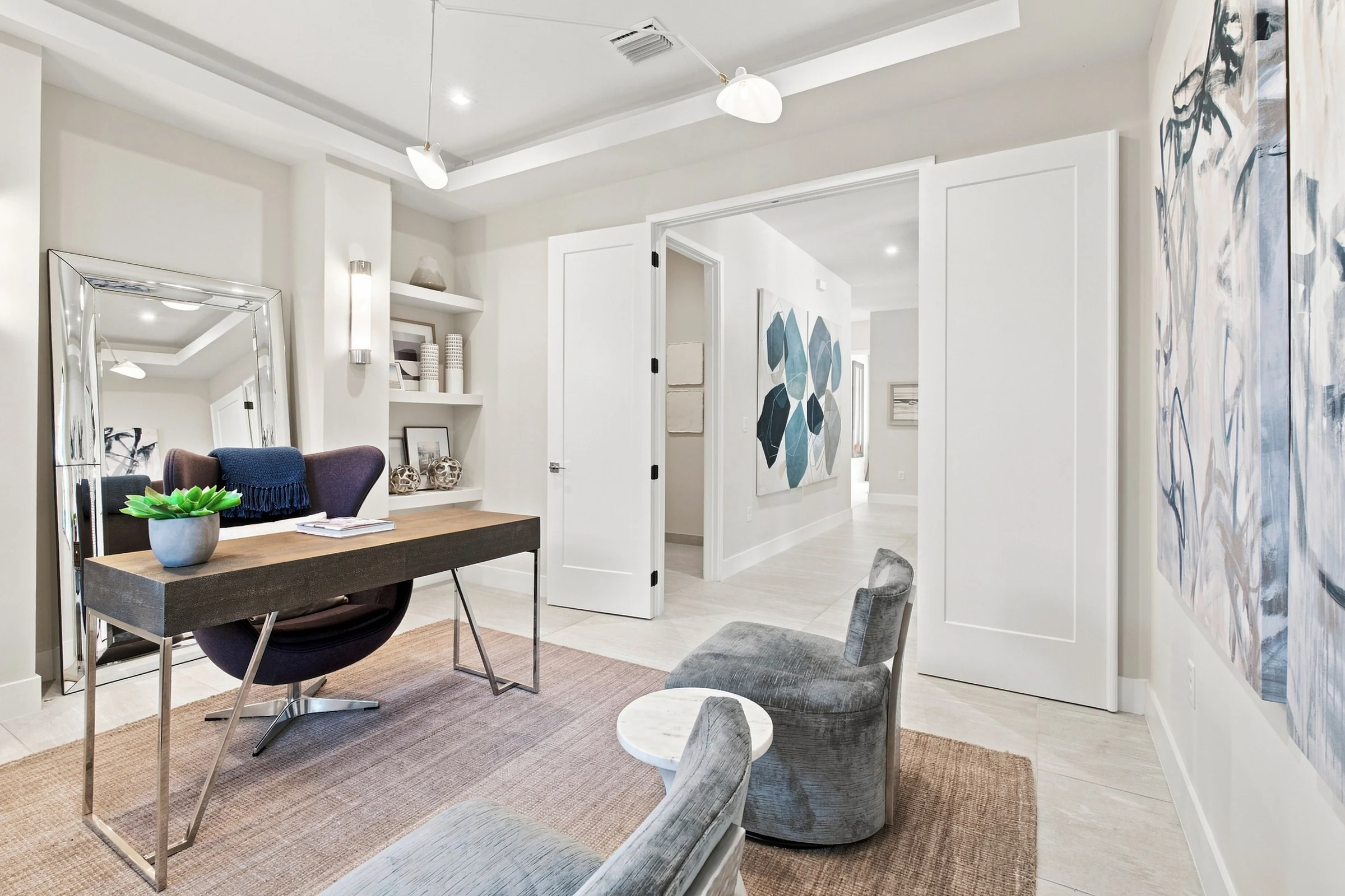 Study with a desk, accent chairs and artwork