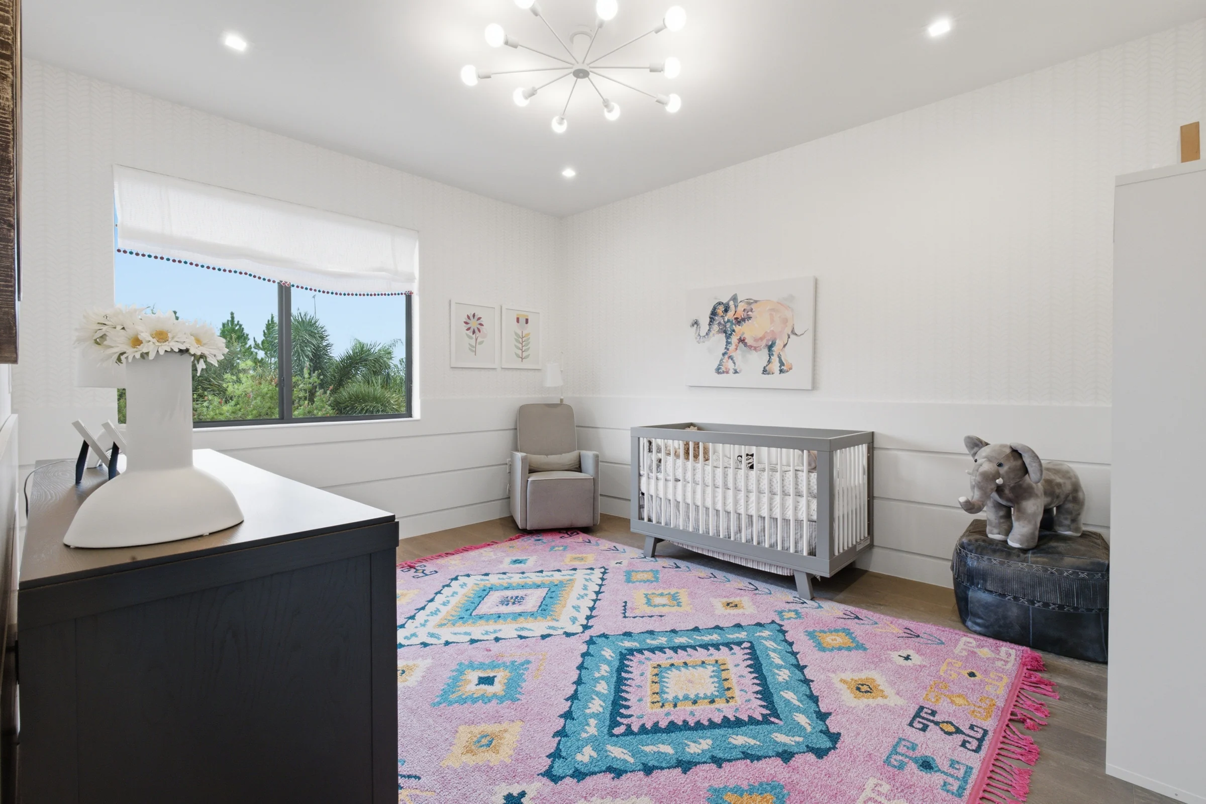Nursery with a crib and a colorful patterned rug